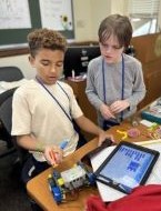 Two students working on a vex robot